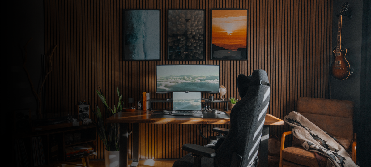 Home office with a computer setup, wall art, and a guitar