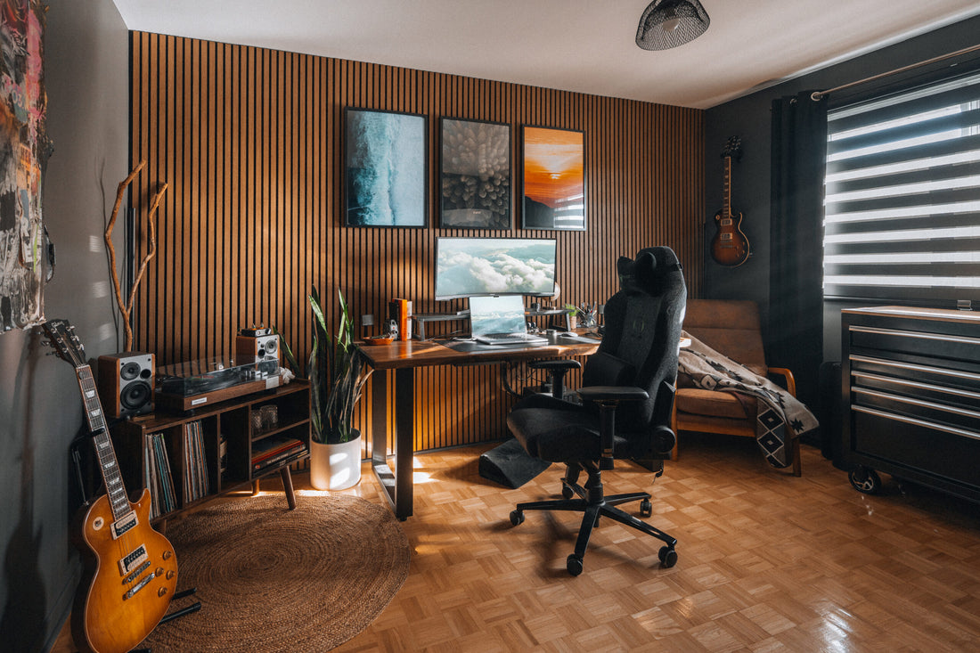 Modern home office with wooden walls, desk, and musical instruments.